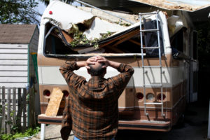 Man With Both Hands On His Head Distressed About Damaged RV